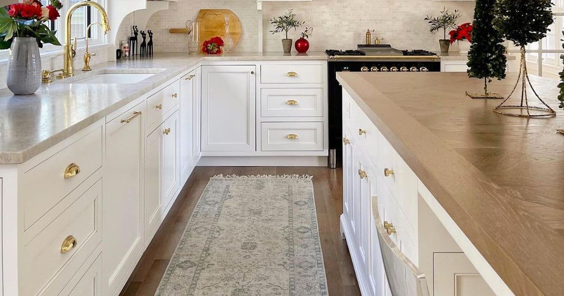 A white kitchen cabinets in a modern kitchen with a kitchen rug.