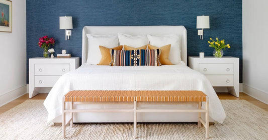 Modern coastal bedroom with a navy accent wall, white bed, and neutral textured area rug.