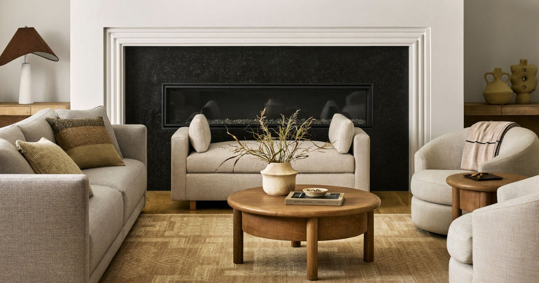 Cozy living room with neutral furniture, a wooden coffee table, and a warm beige area rug.