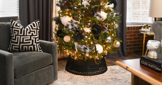 Cozy living room with modern Christmas tree, gray armchair, and chic neutral rug.