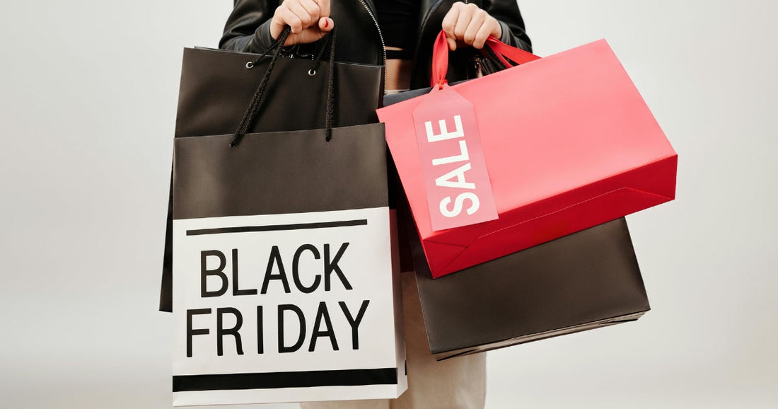 Person holding Black Friday and sale shopping bags, ready for holiday deals and discounts.