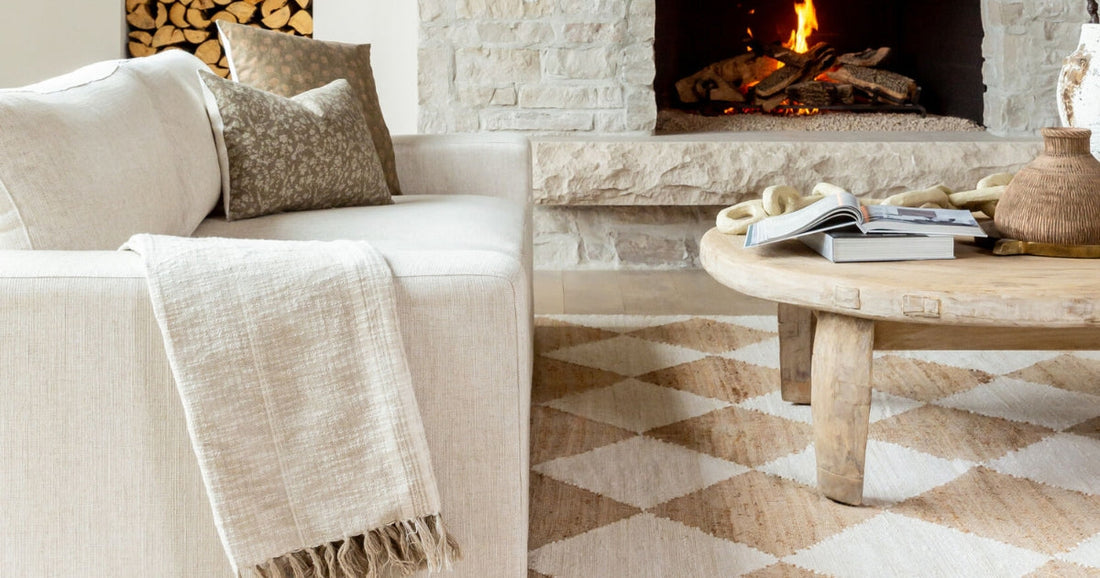 Living room with a rustic fireplace, beige sectional, and geometric-patterned natural fiber rug.