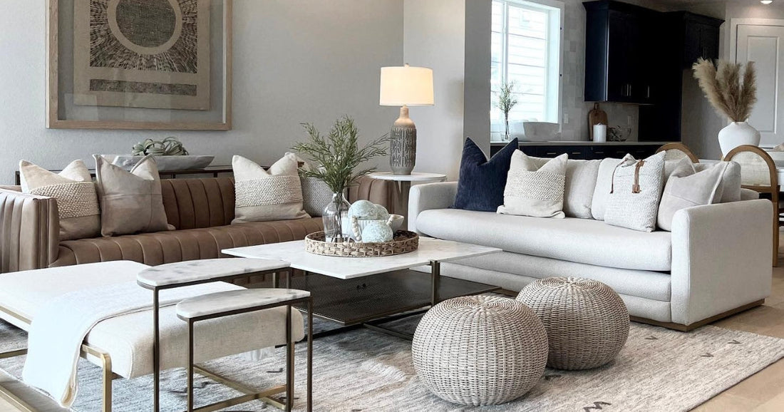 Neutral living room with cozy seating, woven poufs, layered textiles, and a stylish area rug.