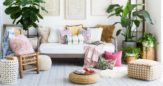 Bright boho-chic living room with colorful pillows, cozy textures, lush plants, and stylish decor.