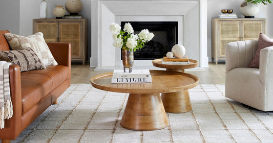 Wooden coffee tables with soft neutral accents and cozy textures in a modern living room.