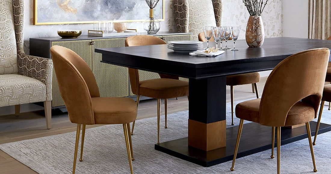 Elegant dining room featuring a modern black table, mustard velvet chairs, and a gray area rug.