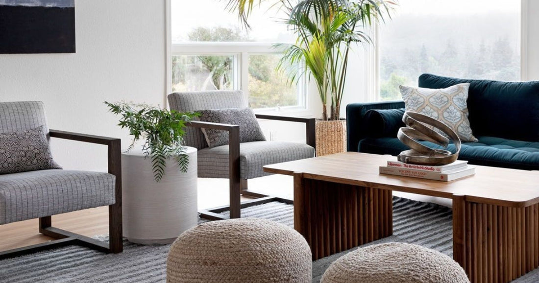 A living room with a Vertou Modern Light Gray Area Rug, a blue sofa, armchairs and a coffee table.
