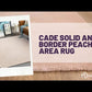 Cade Solid and Border Peach Area Rug